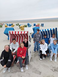Das Foto zeigt die Teilnehmerinnen und Teilnehmer des TGG am Schulsportassistenten-Camp auf Langeoorg vor oder in Strandkörben (Juni 2023)