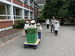 Das Foto zeigt die Honeymakers, wie sie den Honig über den Schulhof abtransportieren.