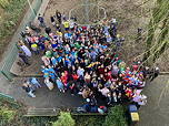 Das Foto zeigt die Fünftklässler von oben in ihren Faschingskostümen auf dem Spielehof (Februar 2024).