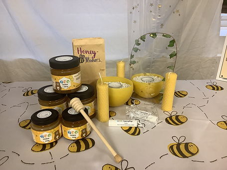 Das Foto zeigt die von den Honeymakers hergestellten Produkte auf einer Decke mit Bienenmotiven.