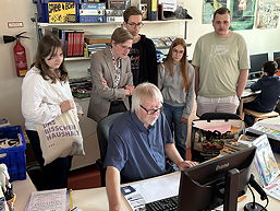 Das Foto zeigt Projektteilnemer/innen mit Herrn Zuudema bei der Einpflegung der Bücher in das Bibliotheksverwaltungssoftware (Juli 2023).