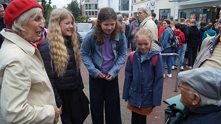 Das Foto zeigt AG-Teilnehmerinnen im Gespräch mit Albrecht Weinberg unmittelbar nach der Stolperstein-Verlegung.